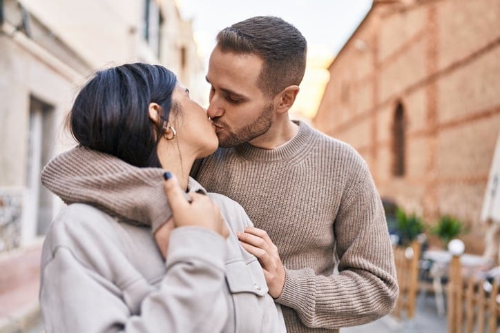couple kissing on city street