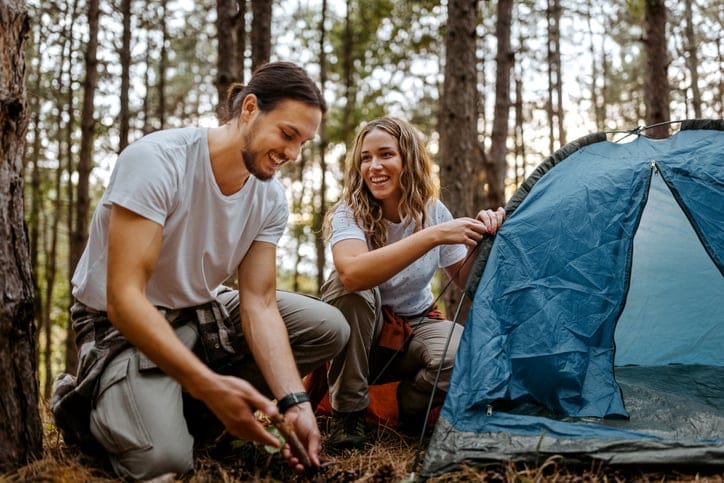 couple on camping trip making fire