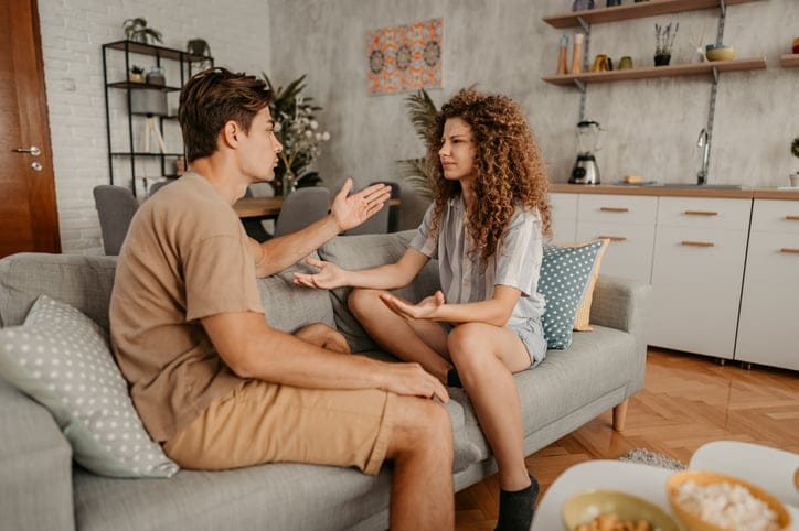 young couple arguing on couch