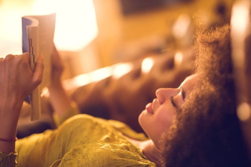 Black woman lying down reading