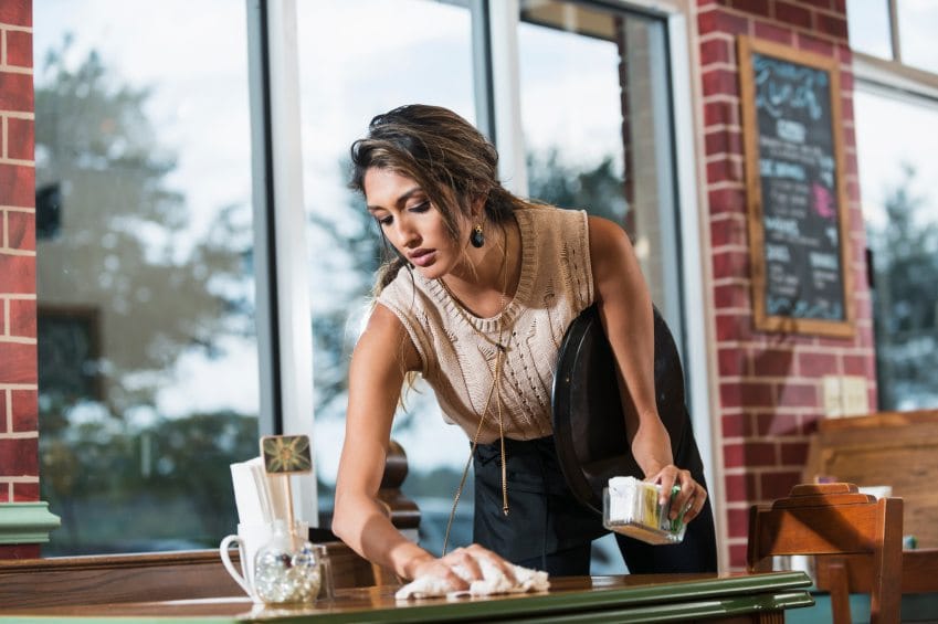 waitress cleaning table at cafe