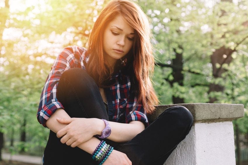 sad teen girl alone at park