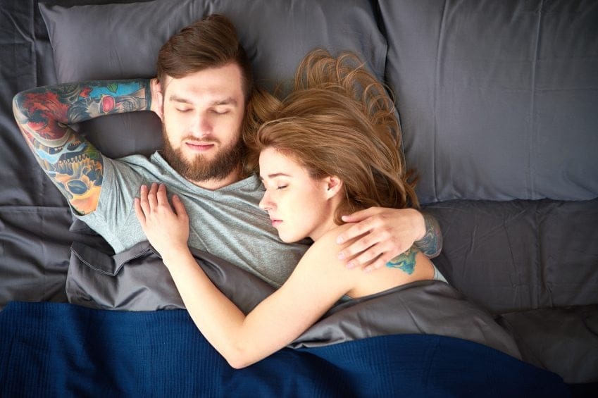Young sleeping couple laying in bed