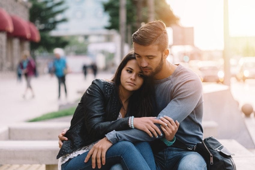 sad couple embracing outdoors