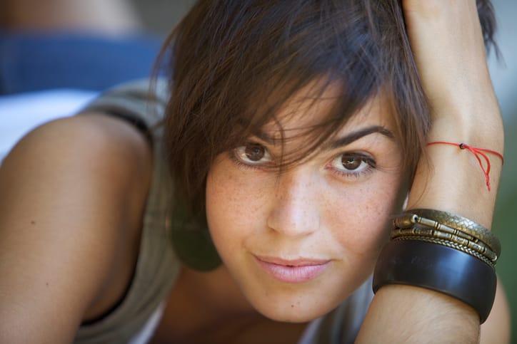 Nice looking young woman with hand in her hair.