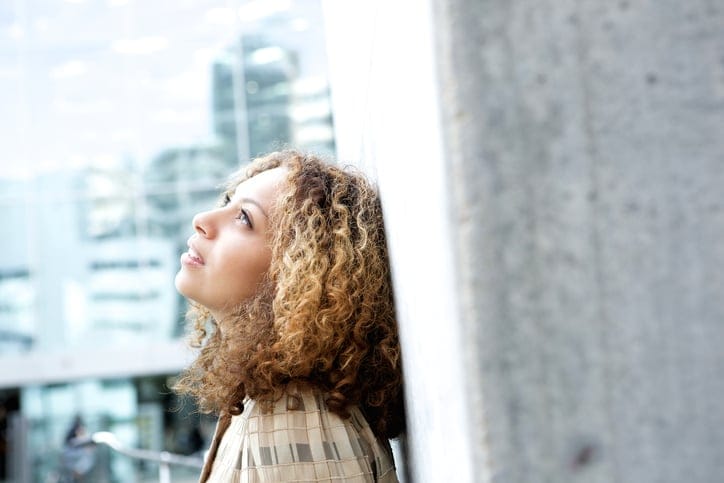 Beautiful young woman looking up