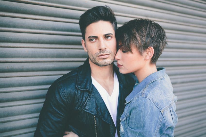 Modern couple against wall