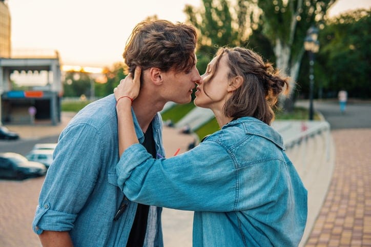 hipster couple kissing at sunset outdoors
