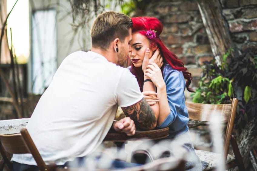 hipster couple holding each other
