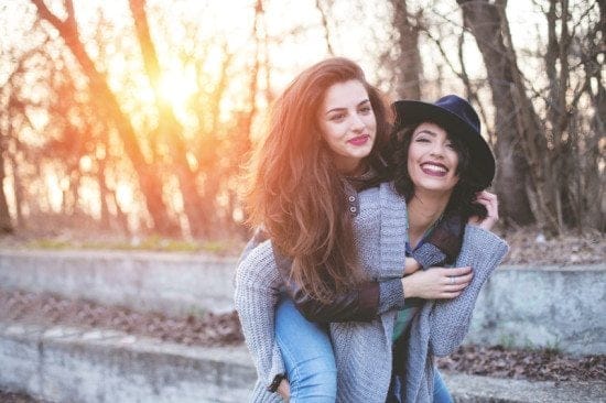 2 female friends riding piggyback