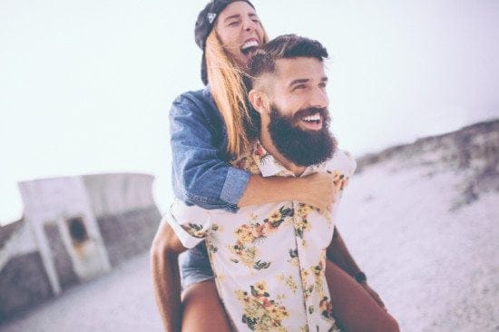 laughing couple riding piggyback