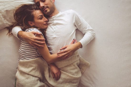 couple cuddling in bed together