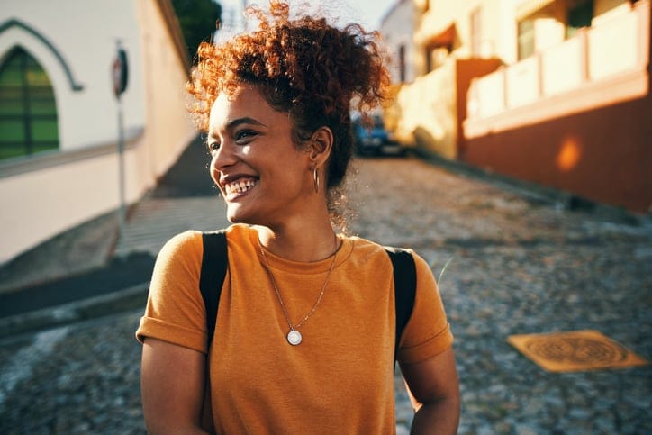 smiling woman curly hair city street