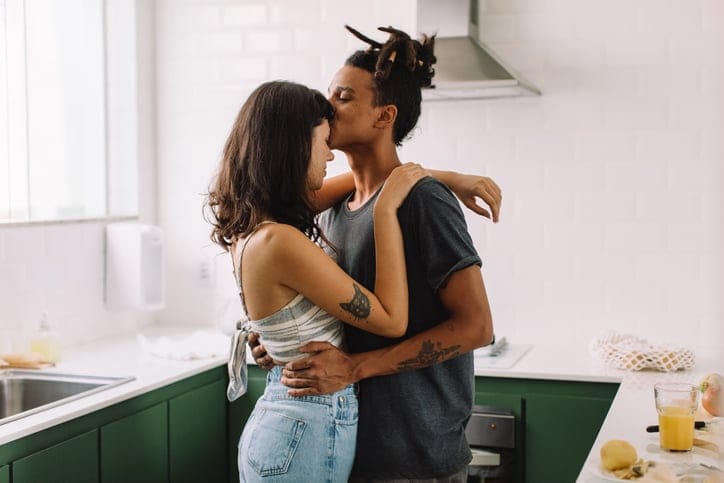 couple kissing in kitchen