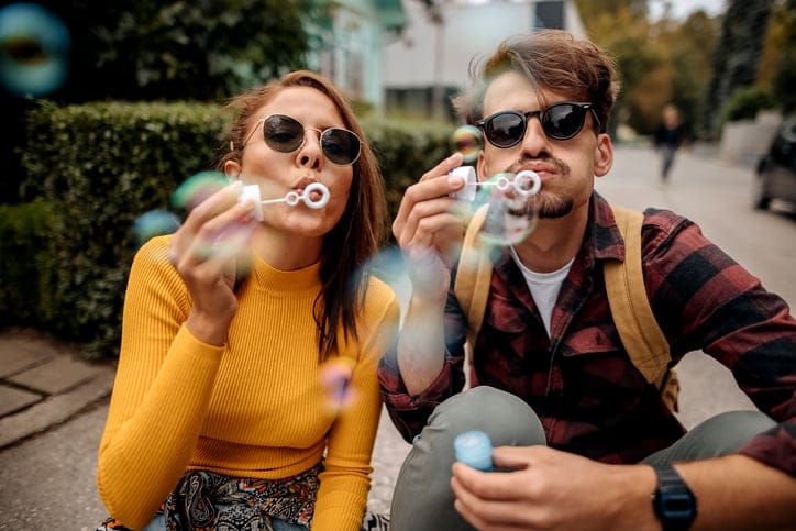 happy couple blowing bubbles