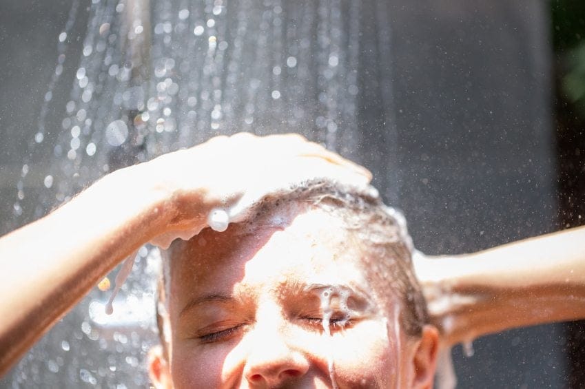 woman washing hair in outdoor shower