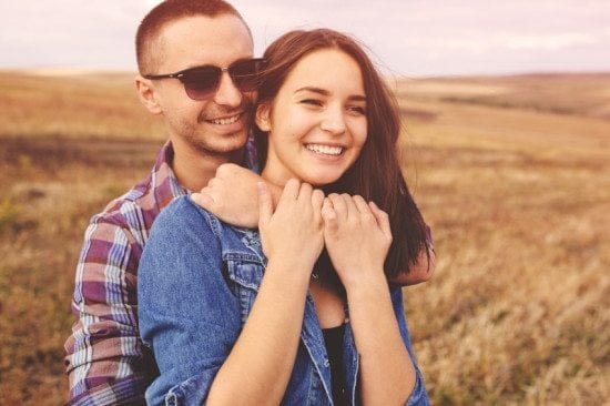 couple embracing in field of wheat