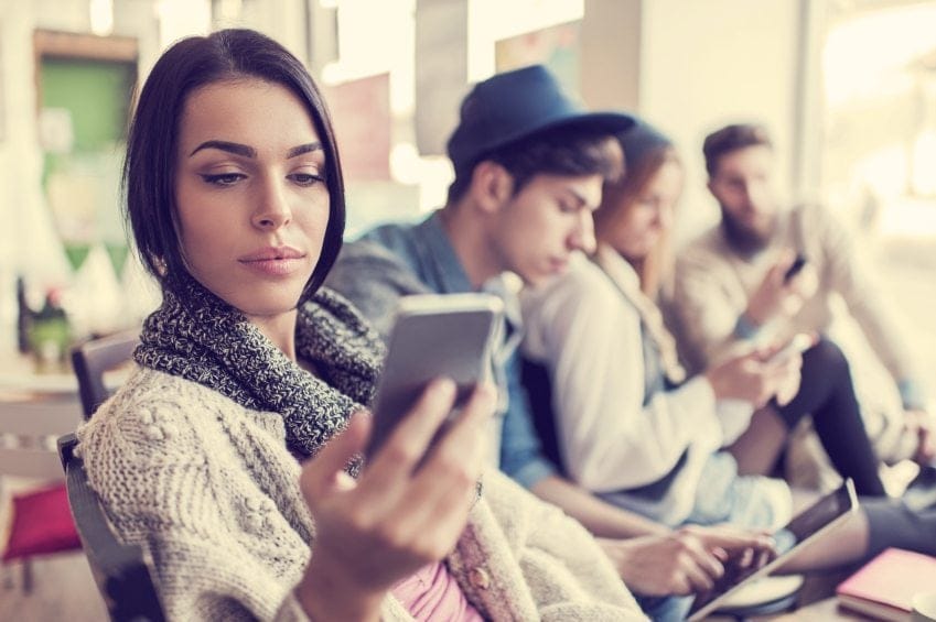 woman sitting looking at her smartphone