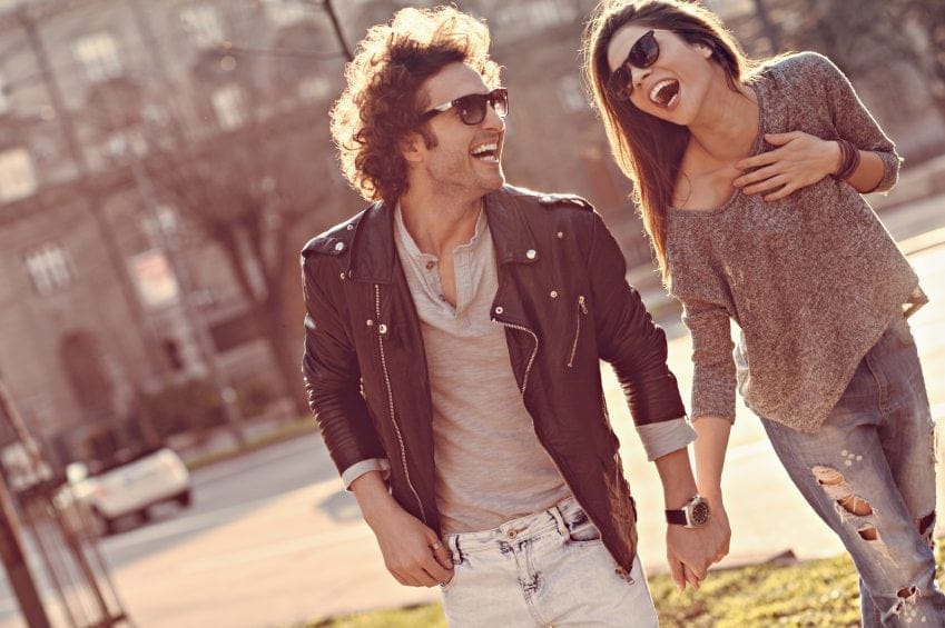 man woman laughing sunshine walking