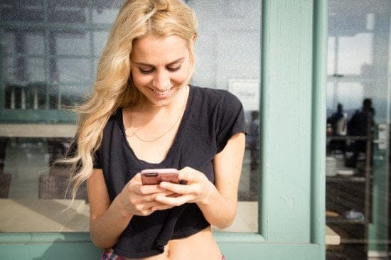 blonde woman texting outdoors