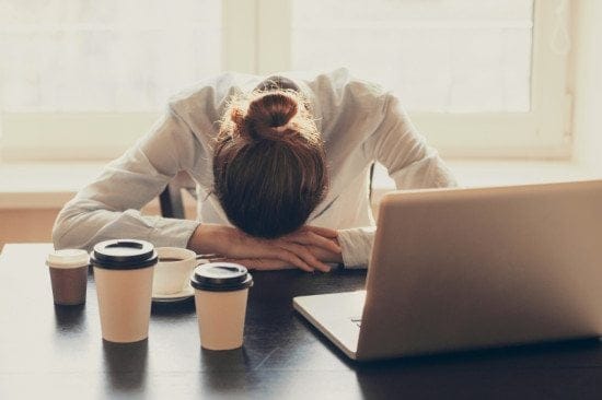 exhausted female office worker with head down