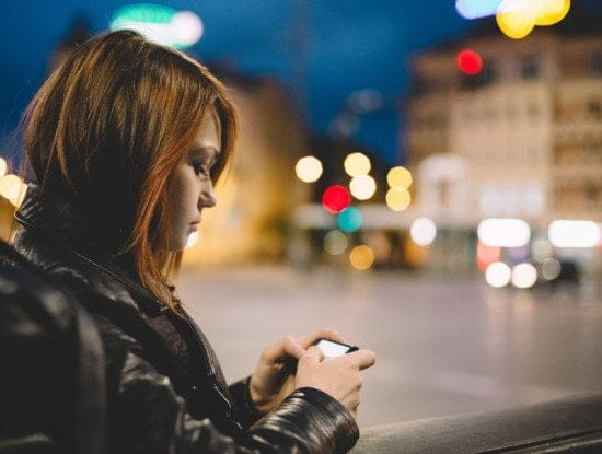 serious teen girl texting at night