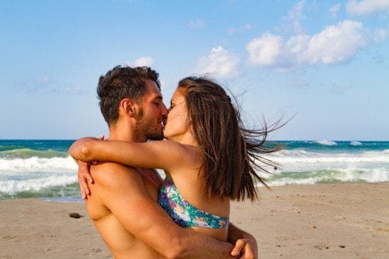 affectionate couple kissing on beach