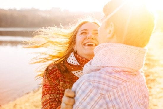 laughing couple by winter lakeside