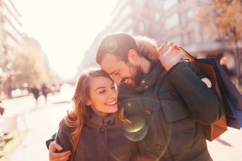 smiling couple walking in winter city