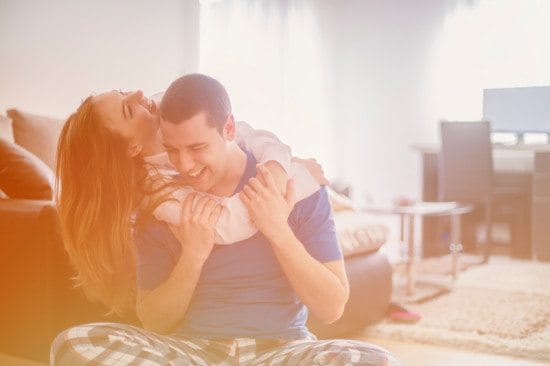 laughing couple cuddling at home