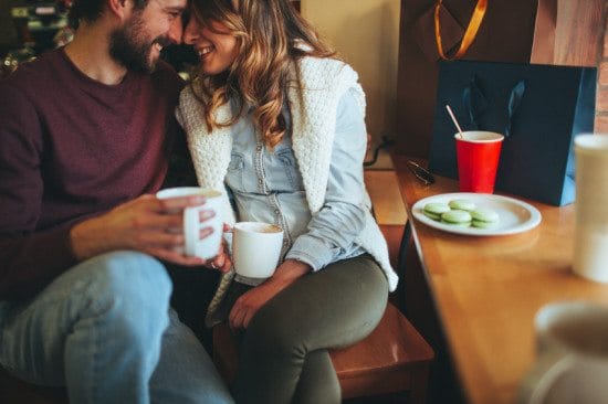 couple with coffee and macaroons at cafe