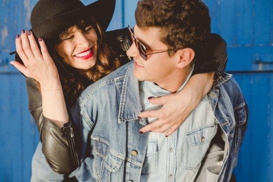 smiling man and woman in front of blue wall