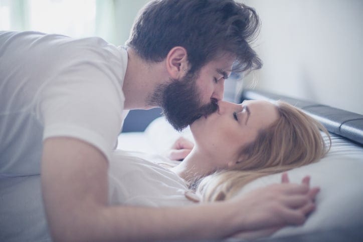 couple kissing bed
