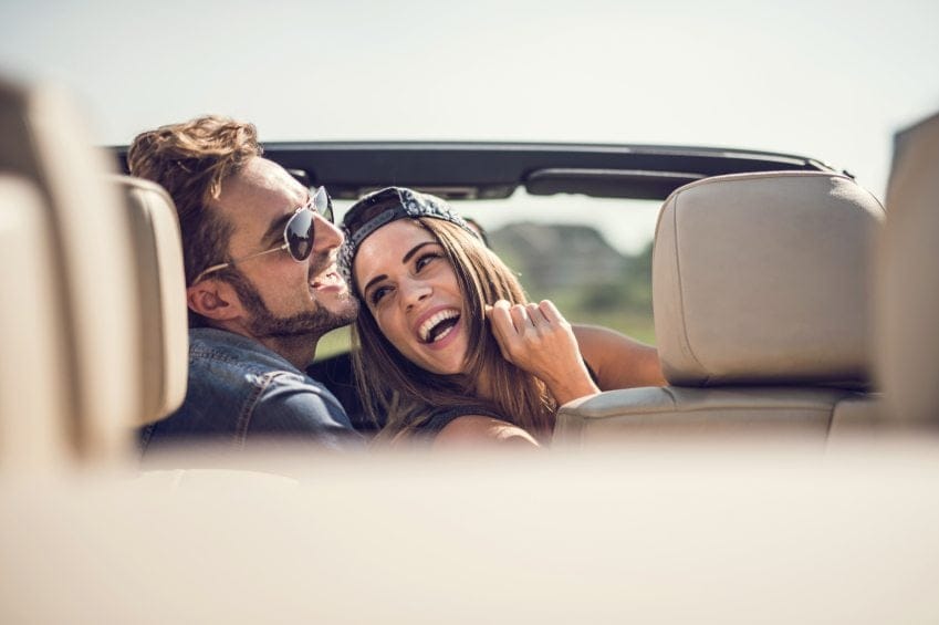 couple laughing in convertible car
