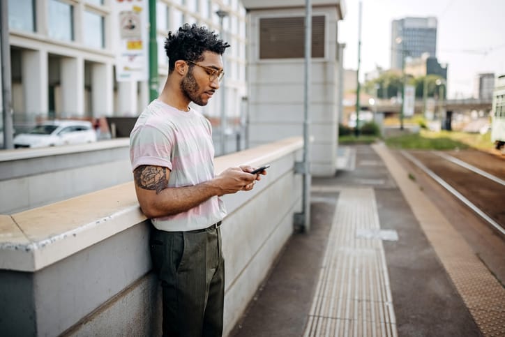 hipster guy texting in city