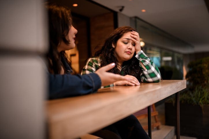 friends having serious conversation at bar