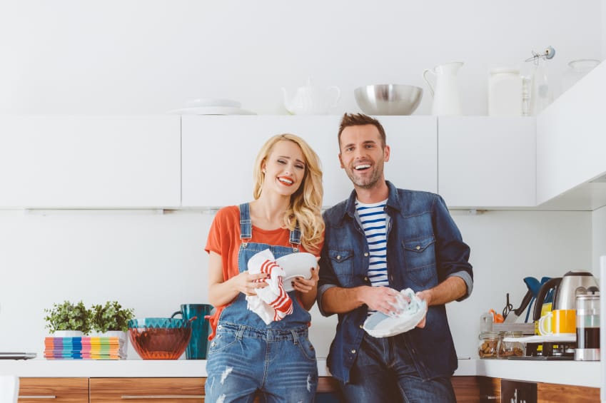 Man and woman in the kitchen doing dishes.
