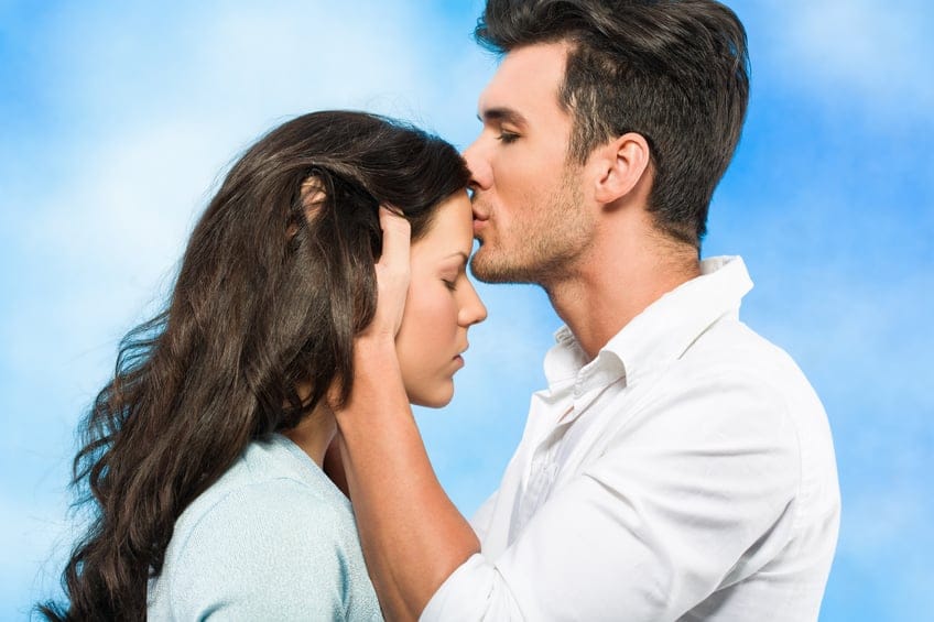 couple close man kissing woman's forehead