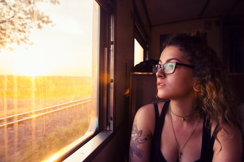 Young American Travels Thailand by Train at Sunrise