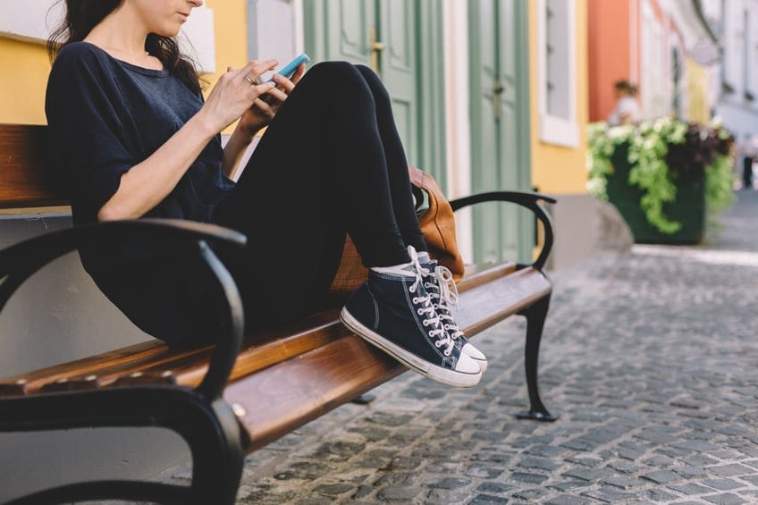 woman bench texting phone