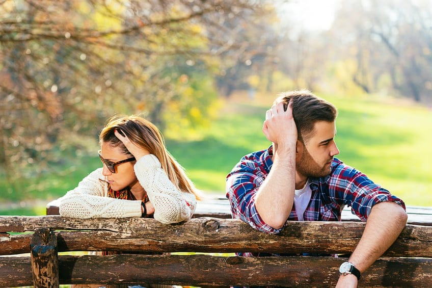 Young attractive couple having relationship issues in park