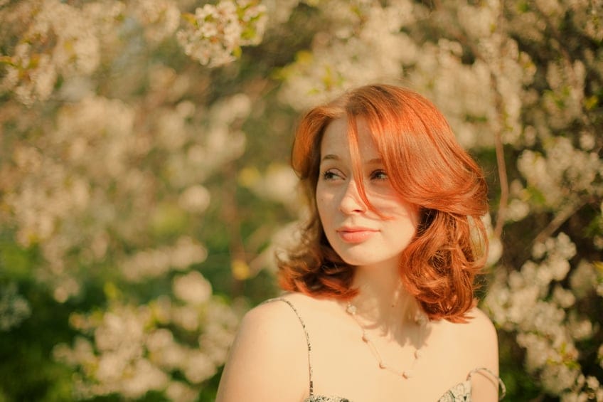 Redheaded girl in blooming garden