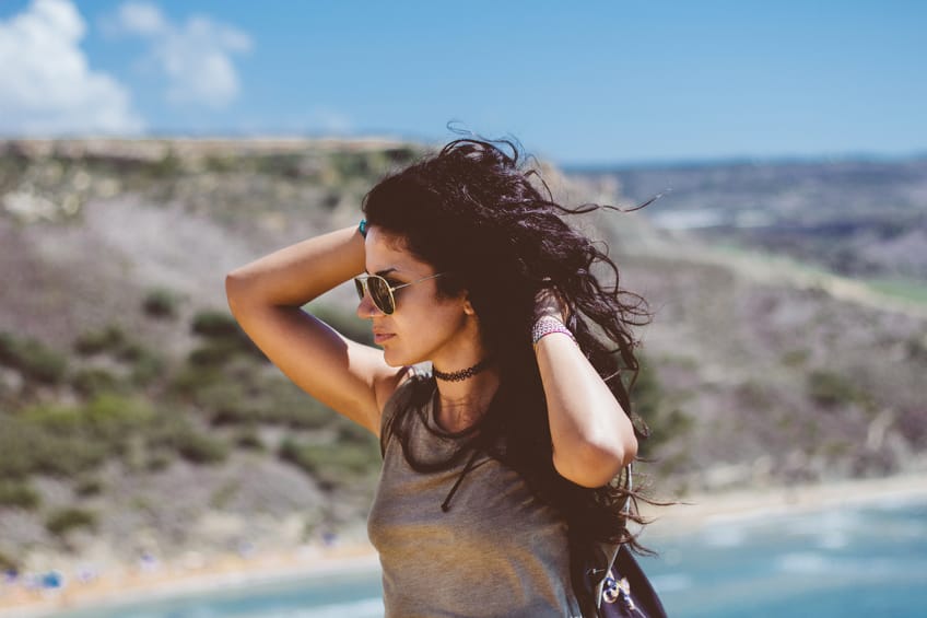 Attractive girl looking pensively on a windy summer day