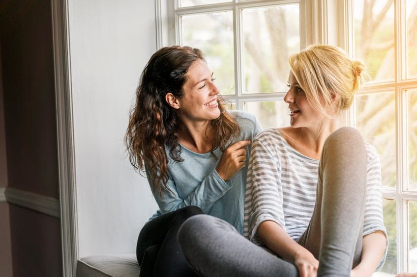 Two women talking window sill