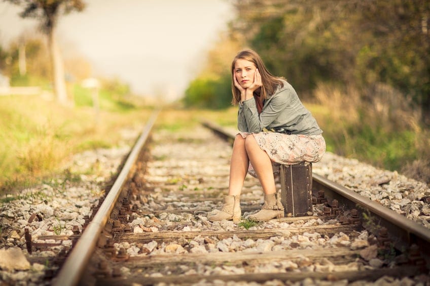 woman sitting on a train track