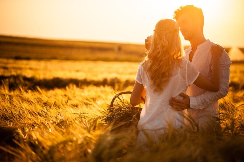 Couple in wheat field on sunset