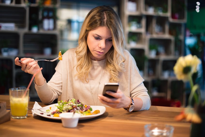 Young woman in the restaurant reading something