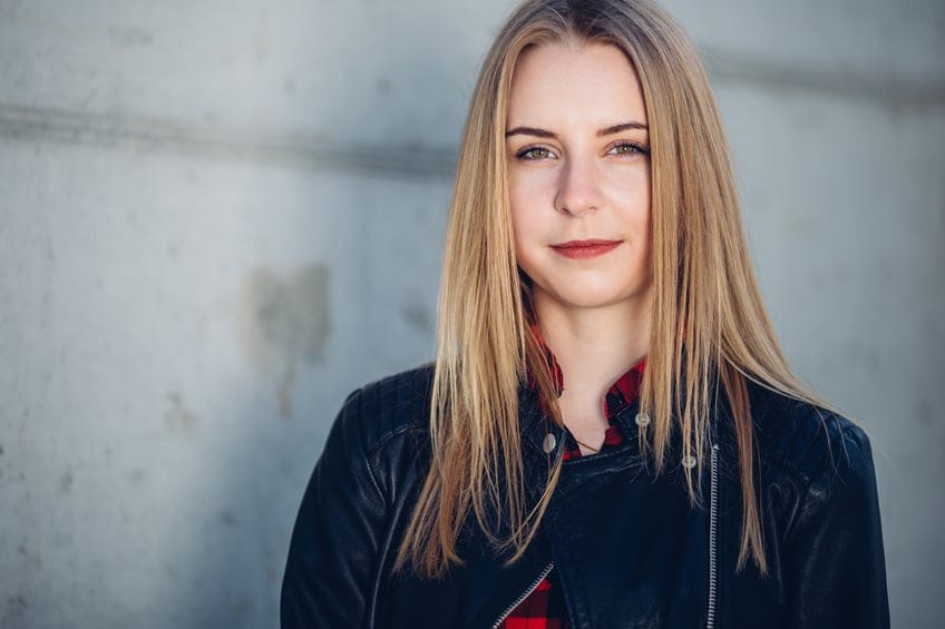 Portrait of young pretty girl standing on the street
