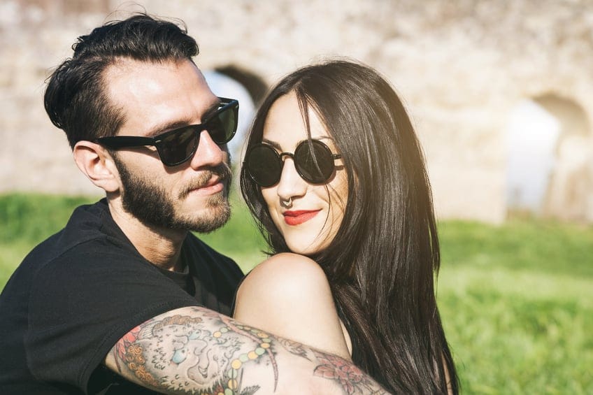 Young couple in love look each other in a sunny day at the park