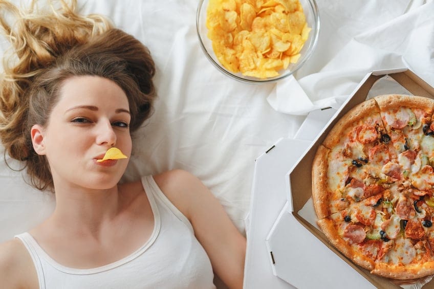 woman bed pizza chips